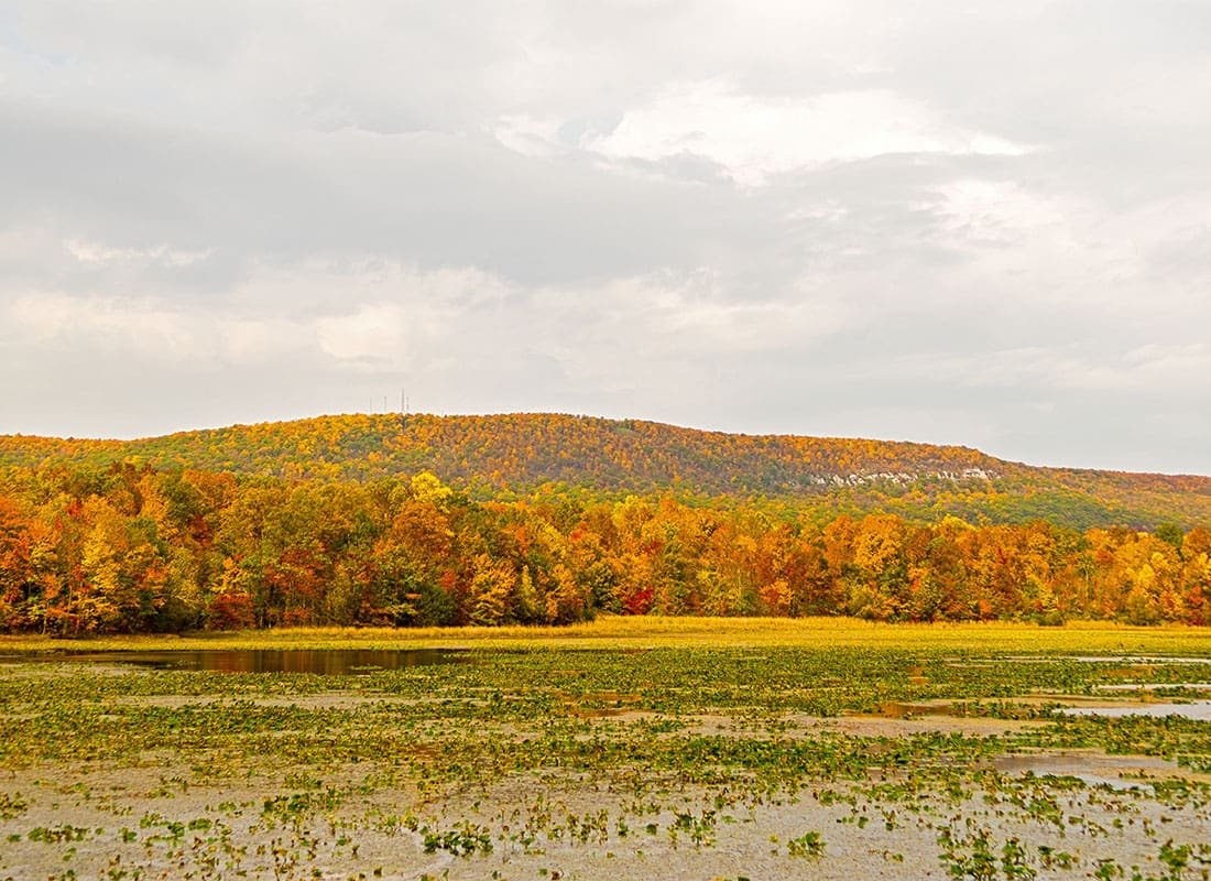 Northampton, PA - Scenic View of a Lake Next to Mountains with Colorful Fall Foliage on a Cloudy Day in Northampton Pennsylvania